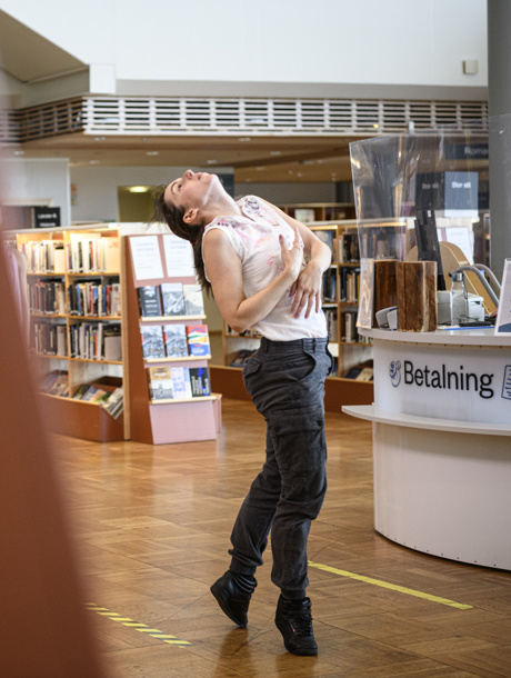 Ensam dansare framför den samtida dansföreställningen If Only I Knew på ett bibliotek