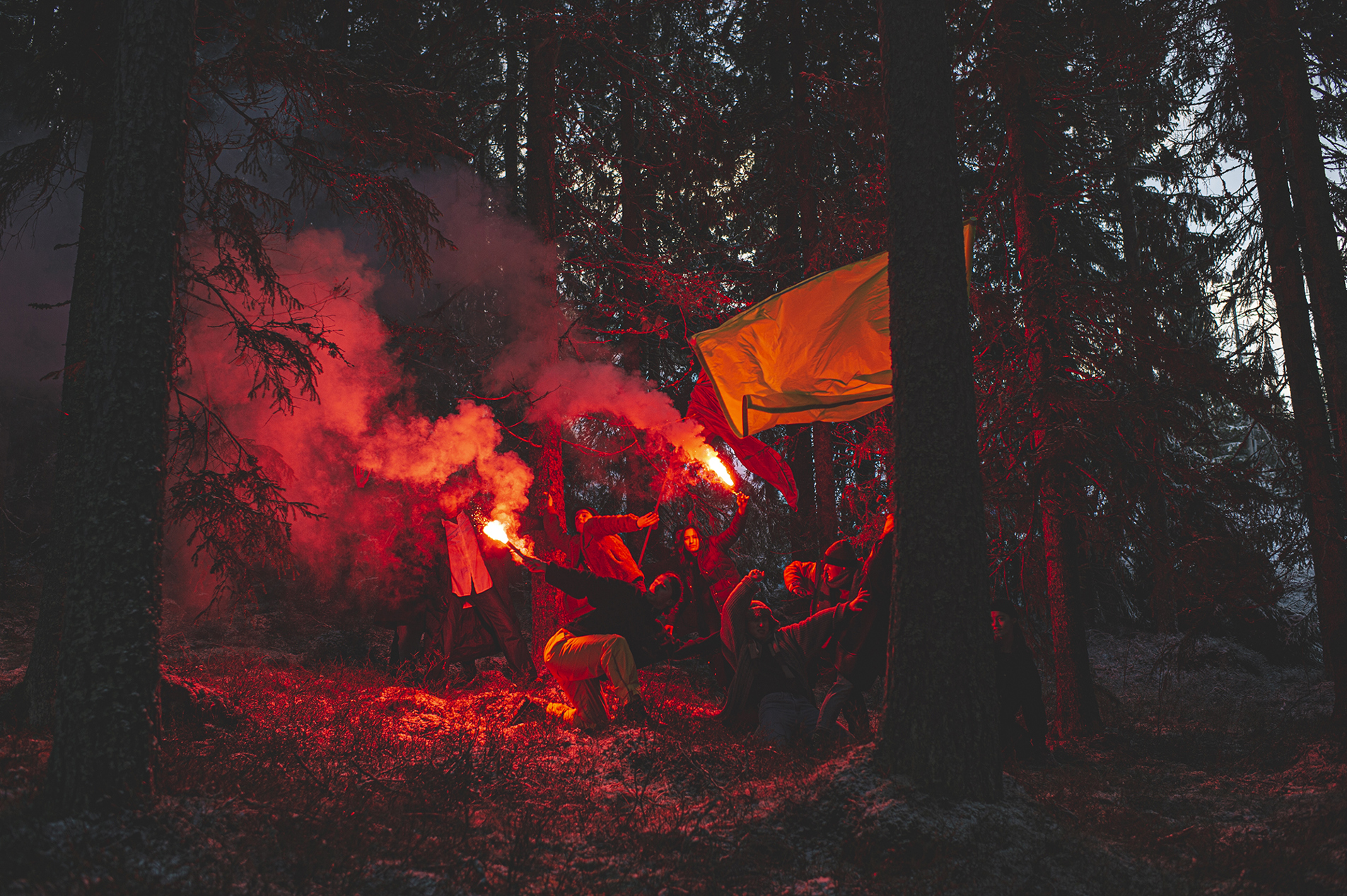 Dancers from the contemporary dance company Norrdans are dancing in a forest with smoke and signal lights.
