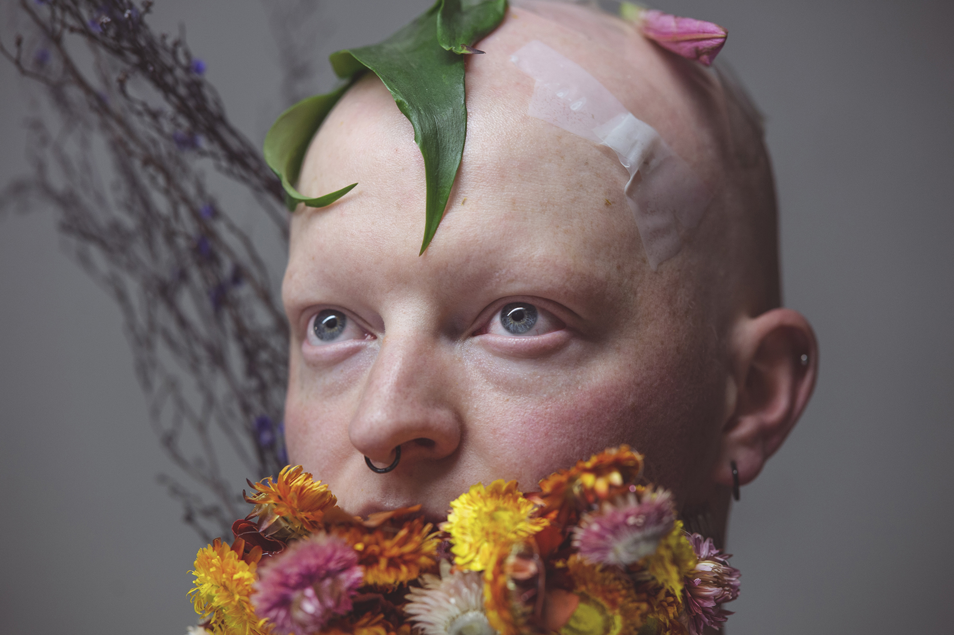 Norrdans dansare i närbild med blommor tejpade i ansiktet.