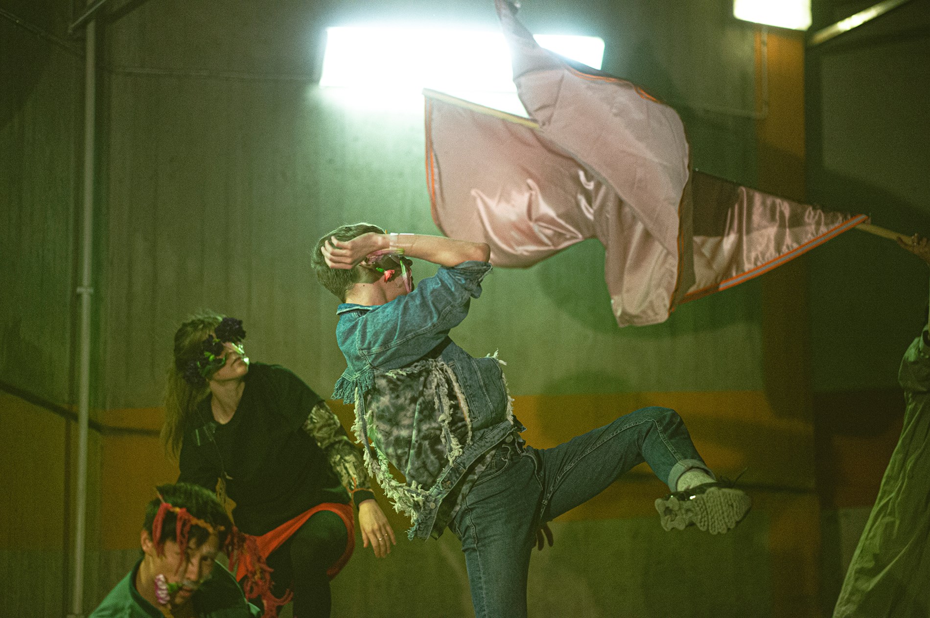 Dansare från det samtida danskompaniet Norrdans dansar med tyger i en lagerlokal